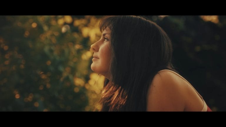 Pia Klein, wie sie in einem Bild in der Natur sitzt und die Umgebung der Stadt genießt.